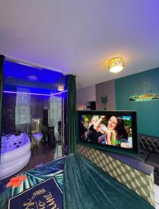 a room with a bed with a tv on the wall at Gold Glass Jacuzzi Sauna Rynek-Parking in Kielce