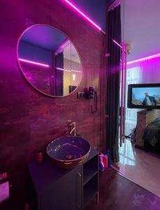 a bathroom with a sink with a mirror and a tv at Gold Glass Jacuzzi Sauna Rynek-Parking in Kielce