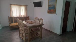 kuchnia ze stołem, krzesłami i telewizorem w obiekcie Paz y Vino w mieście Lujan de Cuyo