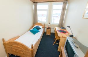 a bedroom with a bed and a desk with a computer at Hotel Svartisen in Mo i Rana