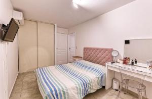 a small bedroom with a bed and a desk at Coquette Maison de Village in Maillane