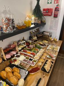 un buffet con muchos tipos diferentes de comida en una mesa en Green Apart en Środa Śląska
