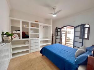 ベルチオガにあるCasa pé na areia em Bertiogaのベッドルーム(青いベッド1台、白い棚付)
