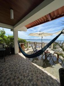 a hammock and an umbrella on a patio at Hotel y Restaurante Mama Ines in Santa Catalina