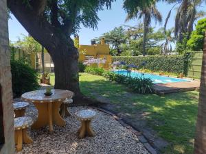 a backyard with a table and a tree and a pool at Alma Mía in Lobos