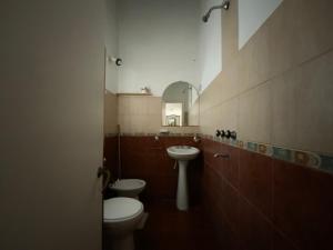 Un baño con dos inodoros, un lavabo y un espejo. en Complejo Quimey No se alquila a jóvenes y se reserva con el 30 porciento del total mediante depósito bancario, en Villa Gesell 48 fotos más