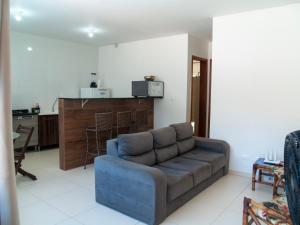 sala de estar con sofá y cocina en Cada com piscina 50mts da praia!, en Itapoa