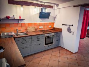a kitchen with a sink and a stove top oven at Kuhstall Sinzenich in Zülpich +5 photos