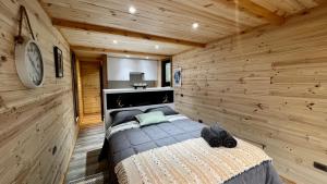 1 dormitorio con 1 cama en una habitación de madera en Puerta austral, en Puelo