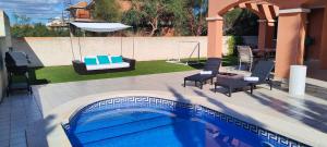 a swimming pool with two chairs and a swing at Villa Veneziola La Manga in Murcia