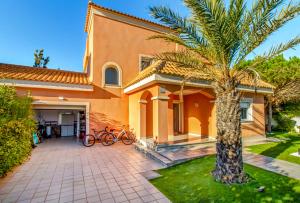 a house with a palm tree in front of it at Villa Veneziola La Manga in Murcia