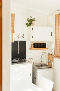a white kitchen with a sink and a stove at Kanaal kooi in Upington