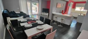 a dining room and living room with a table and chairs at Villa Veneziola La Manga in Murcia