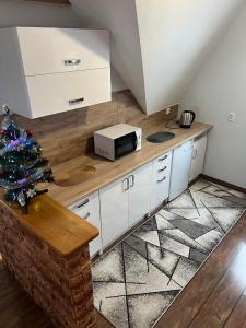 a kitchen with a counter with a microwave and a christmas tree at Apartament u Mrugały in Biały Dunajec