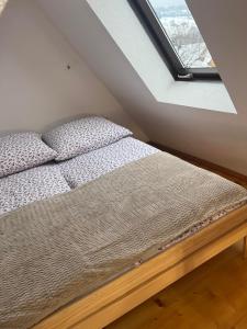 Bett in einem Zimmer mit Fenster in der Unterkunft Apartament u Mrugały in Biały Dunajec