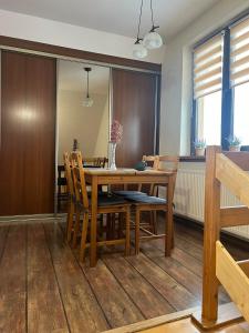 a dining room with a wooden table and chairs at Apartament u Mrugały in Biały Dunajec