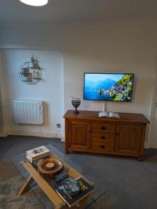 a living room with a flat screen tv on a wooden cabinet at Avon’s Rest in Stratford-upon-Avon