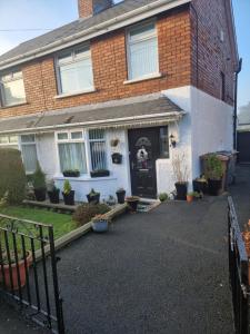 a brick house with a black door and a driveway at Breda Lodge Cosy Studio Space in Belfast