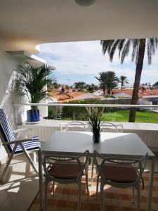 un tavolo bianco e sedie sul balcone di TAMARAN (ENTRE YUMBO ET CITA) a Playa del Ingles