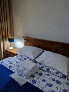 a blue and white bed with two towels on it at Friendly Guest House in Kutaisi