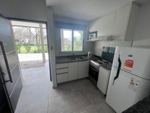 a kitchen with a white refrigerator and a stove at Pilar Norte. Departamentos in La Lonja