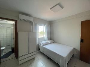 Habitación blanca con cama y ventana en Residencial Carajás en Goiânia