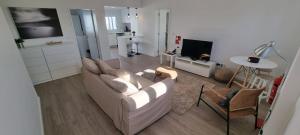 a living room with a white couch and a tv at Casa do Pescador in Lagoa