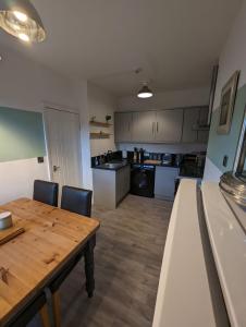 a kitchen with a wooden table and a dining room at Avon’s Rest in Stratford-upon-Avon