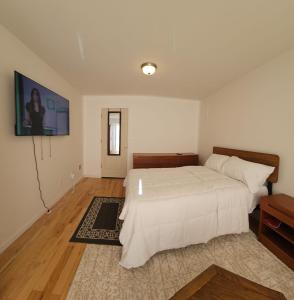 ein Schlafzimmer mit einem Bett und einem TV an der Wand in der Unterkunft Traveler's Lodge In Newark City in Newark