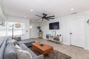 uma sala de estar com um sofá e uma ventoinha de tecto em Luxury Tampa home King bed 4BR em Tampa