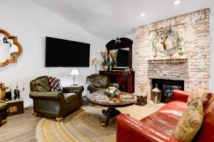 a living room with leather furniture and a brick fireplace at Antlers - A Birdy Vacation Rental in San Antonio