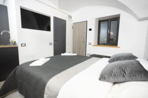 Un dormitorio blanco con una cama y un televisor. en Balcescu Residence, en Brasov