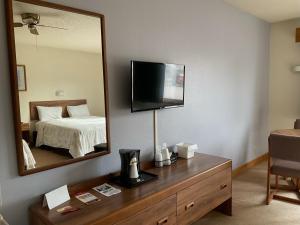- une chambre d'hôtel avec un lit et un miroir dans l'établissement Great Northern Motel, à Mercer