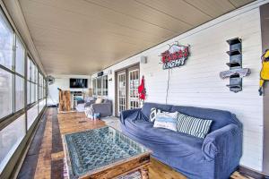a living room with a couch and a sign on the wall at Lake Ozark Vacation Home with Hot Tub and Dock! in Lake Ozark