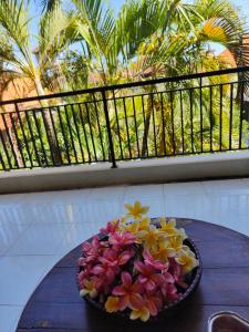 a bowl of flowers on a table on a balcony at Berlian Inn Kuta Beach in Kuta