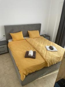 ein Bett mit zwei Hüten und Handtüchern darauf in der Unterkunft ViVo Beach Apartment in Durrës