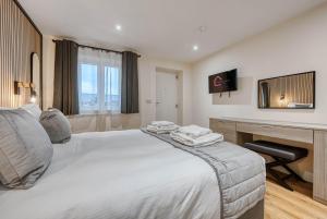 a bedroom with a bed and a desk with a computer at Luxury Stockton Studio Rooms, Free WiFi & Parking 
