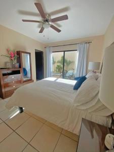 a bedroom with a large bed with a ceiling fan at Casa del Mar, Sunset Beach, large house for groups in Cabo San Lucas