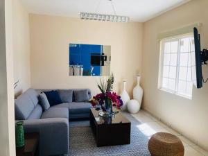 a living room with a blue couch and a table at Casa del Mar, Sunset Beach, large house for groups in Cabo San Lucas