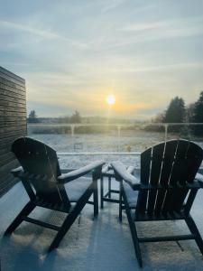 two chairs sitting on a porch in the snow at Le Mont Rigi in Waimes