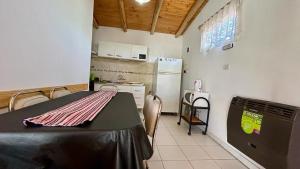 uma cozinha com uma mesa e um frigorífico em Valles del Sur - Malargüe em Malargüe