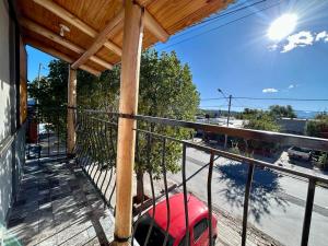 einen Balkon mit einem roten Auto auf einer Straße in der Unterkunft Valles del Sur - Malargüe in Malargüe
