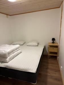 a bedroom with two beds and a night stand at Joy Stugan Näsfjället in Sörsjön