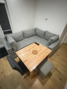 ein Wohnzimmer mit einem Sofa und einem Holztisch in der Unterkunft Apartmani Andjela in Jahorina