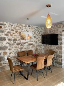 Un comedor con mesa y sillas de madera. en Adeste to Lasithi Luxury Apartment, en Mésa Lasithákion