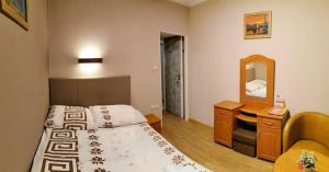 małą sypialnię z łóżkiem i lustrem w obiekcie Usługi Noclegowe i Gastronomiczne dla Ludności Robert Mielcarek w Kobylej Górze