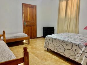 - une chambre avec 2 lits et une porte en bois dans l'établissement Floripa Camping e Hostel, à Florianópolis