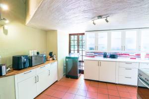 a kitchen with white cabinets and a black refrigerator at Brooklyn's Holiday Home in Pretoria