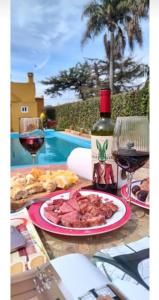 una mesa con un plato de comida y dos copas de vino en Alma Mía en Lobos