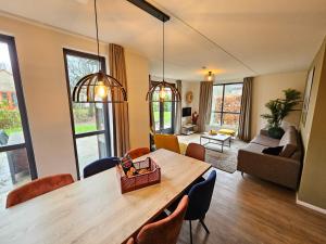 a living room with a large wooden table and chairs at New 3 bedroom house 7 people in Ewijk